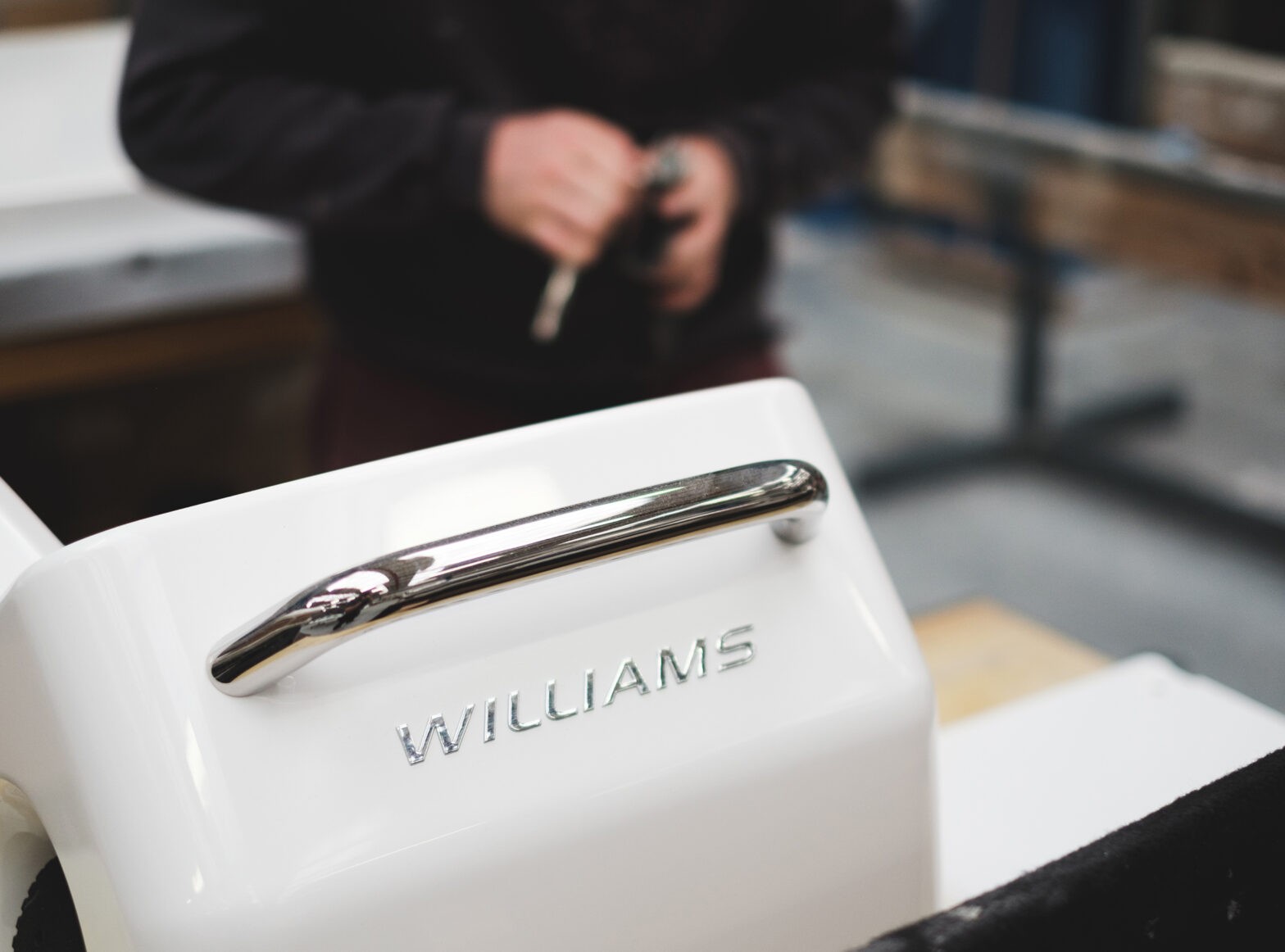 Close-up of a Williams Jet Tender handle, with a person working in the background.